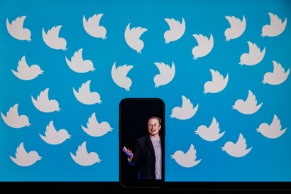 Elon Musk appears on a black phone amid Twitter logos
