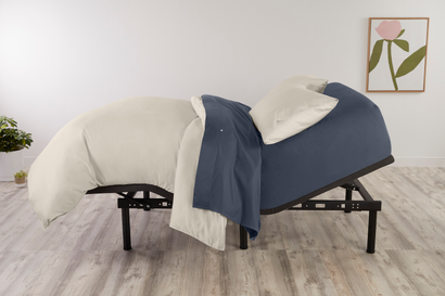 An adjustable bed frame with the top half set to an incline.