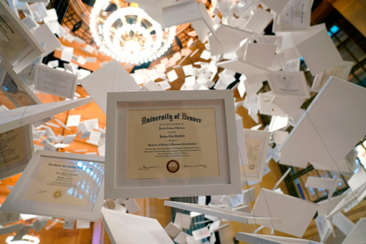 Diplomas are part of artwork, entitled "Da Vinci of Debt," on display at Grand Central Terminal on January 16, 2022, in New York. -