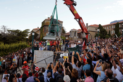 Cheering students surround the decades old bronze statue of British colonialist Cecil John Rhodes, as it is removed from the campus at the Cape Town University, Cape Town, South Africa, Thursday, April 9, 2015, responding to student protests describing it as symbolic of slow racial change on campus.