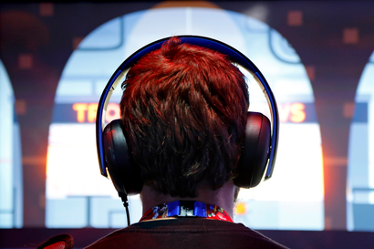 A gamer wears headphones while playing a game at the 2014 Electronic Entertainment Expo.