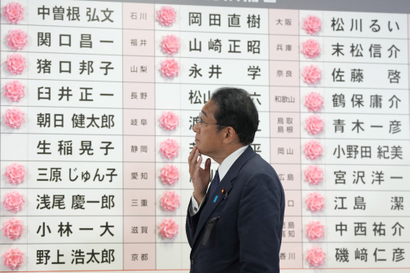 Fumio Kishida, Japan's Prime Minister and president of the Liberal Democratic Party (LDP), reacts after placing a paper rose on an LDP candidate's name, to indicate a victory in the upper house election.