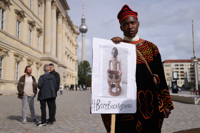 A protester from Cameroon seeking the return of the Ngonnso statue stands outside the Humboldt Forum during the opening of the Humboldt's Ethnological Museum and the Museum for Asian Art on September 22, 2021 in Berlin, Germany.