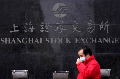 A man walks by the Shanghai Stock Exchange building in the Pudong financial district in Shanghai.