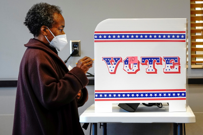 A person stands in a voting booth in Milwaukee