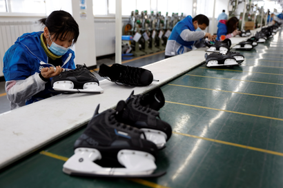A person is working on a pair of ice skates in a factory. 