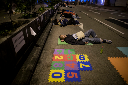 Pro-democracy protesters sleep on a occupied street at Mongkok shopping district in Hong Kong