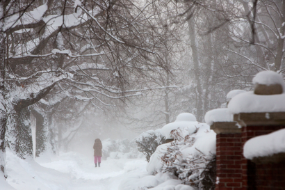 pedestrian walks through a snow storm