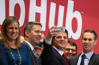 GrubHub CEO Matt Maloney (2nd R) takes a "selfie" photograph before ringing the opening bell, before the company's IPO on the floor of the New York Stock Exchange