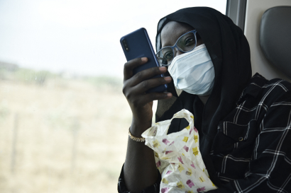 A passenger looks at her phone by the window of the regional express train that left from the Dakar's train station, in Dakar, on January 11, 2022
