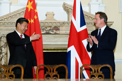 David Cameron and Xi Jinping applaud in front of their countries' flags during a commercial contract exchange in 2015.