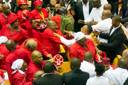 Members of Julius Malema's Economic Freedom Fighters (EFF) (in red) clash with security