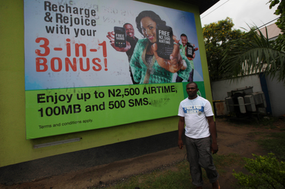 Man walks past telecoms billboard in Nigeria