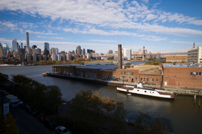 A rusting ferryboat is docked next to an aging industrial warehouse on the Anable Basin, Wednesday, Nov. 7, 2018, in the Queens borough of New York. Across the East River from midtown Manhattan, top left, Long Island City is a longtime industrial and transportation hub that has become a fast-growing neighborhood of riverfront high-rises and redeveloped warehouses, with an enduring industrial foothold and burgeoning arts and tech scenes. (AP Photo/Mark Lennihan)