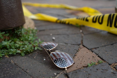 American flag-themed sunglasses laying on the ground at the scene of the Fourth of July parade shooting in Highland Park