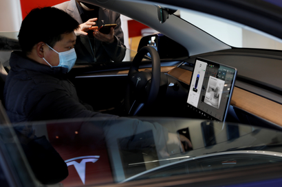 A car buyer examines a Tesla Model Y.
