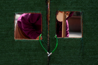 A resident in Shanghai looks out through a barrier during a covid lockdown.