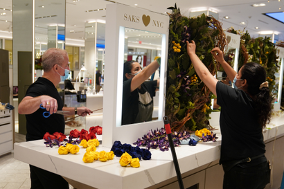 Worker put up flower display at Saks 5th Avenue in New York City.