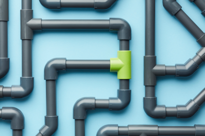 Grey pipe system with one lime green connecter, set against robin's egg blue blackground
