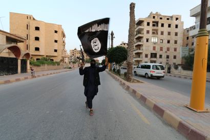 A member loyal to the Islamic State in Iraq and the Levant (ISIL) waves an ISIL flag in Raqqa June 29, 2014. The offshoot of al Qaeda which has captured swathes of territory in Iraq and Syria has declared itself an Islamic "Caliphate" and called on factions worldwide to pledge their allegiance, a statement posted on jihadist websites said on Sunday. The group, previously known as the Islamic State in Iraq and the Levant (ISIL), also known as ISIS, has renamed itself "Islamic State" and proclaimed its leader Abu Bakr al-Baghadi as "Caliph" - the head of the state, the statement said. REUTERS/Stringer (SYRIA - Tags: POLITICS CIVIL UNREST ) BEST QUALITY AVAILABLE - RTR4BHO3