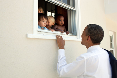 Former President Barack Obama looks into a window with babies from all ethnicities.