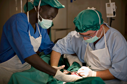 Surgeon Jose Sanchez (R) from Spain operates on a soldier