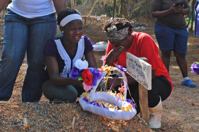Women weep at the grave of lost relative Esther Mulbah at a cemetery for victims of Ebola virus in Suakoko, Liberia