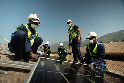 Workers in South Africa install solar panels.