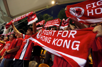 Hong Kong fans sing while holding banners at the World Cup qualifying match between Hong Kong and the Maldives in Hong Kong, China June 16, 2015. Hong Kong's leader warned on Tuesday that violence will not be tolerated, a day after authorities arrested 10 people and seized suspected explosives ahead of a crucial vote on a China-backed electoral reform package this week. Anger has spilled over to football crowds, with supporters of the Hong Kong team loudly booing the Chinese national anthem on Tuesday night at the start of the local World Cup Asian zone qualifying match against the Maldives.