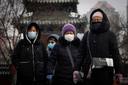 people wear face masks to prevent the spread of covid-19 on a snowy morning in Beijing
