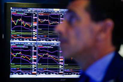 A trader looks at screens as he works on the floor at the New York Stock Exchange (NYSE) in New York