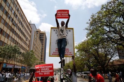 A supporter of Kenya's President Uhuru Kenyatta carries a placard as they demonstrate outside the Supreme Court in protest of the nullification of Kenyattaís victory by the Supreme Court Judges in Nairobi, Kenya, September 19, 2017.