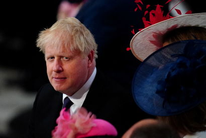 A portrait of Boris Johnson amidst large-brimmed hats at the Queen's Platinum Jubilee celebrations.