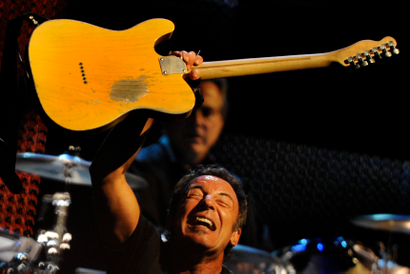 Bruce Springsteen holding up a Fender guitar