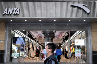 A man walks past a store of Chinese sportswear firm Anta Sports at a shopping mall in Beijing