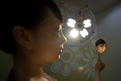 A person looks at their reflection in a small handheld mirror.