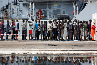 Migrants stand in line after disembarking from the Italian Navy vessel Bersagliare at the Sicilian port of Augusta, Italy, September 16, 2016.
