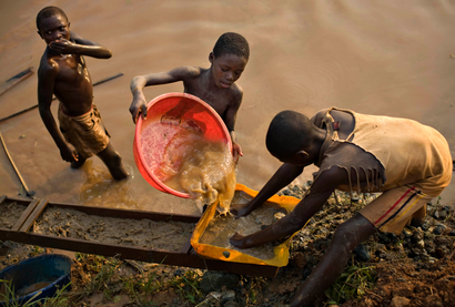 Boys pan for gold on a riverside at Iga Barriere in eastern Congo