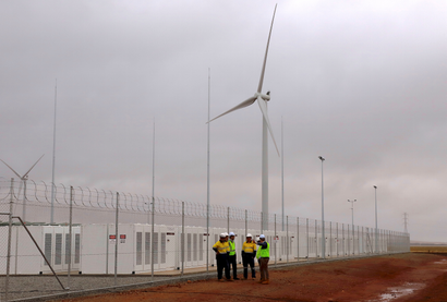 Officials and workers gather outside the compound housing the Hornsdale Power Reserve, featuring the world's largest lithium ion battery made by Tesla, during the official launch near the South Australian town of Jamestown, in Australia, December 1, 2017. REUTERS/David Gray - RC1D99DC5C00