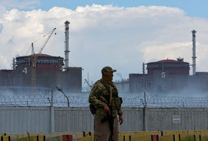 A armed guards stands in front of the Zaporizhzhia nuclear power plant in Ukraine. 
