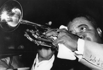 American jazz musician Louis Armstrong plays his trumpet.