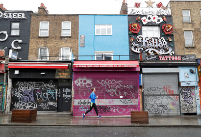 A man runs past closed shops in Camden, as the spread of the coronavirus disease (COVID-19) continues, London, Britain, April 28, 2020