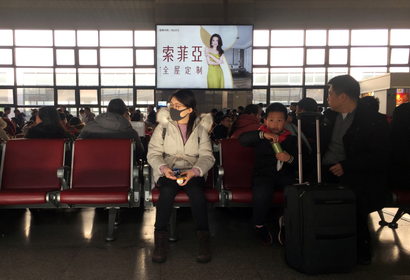 A woman wearing a mask is seen at a waiting area for a train to Wuhan at the Beijing West Railway Station