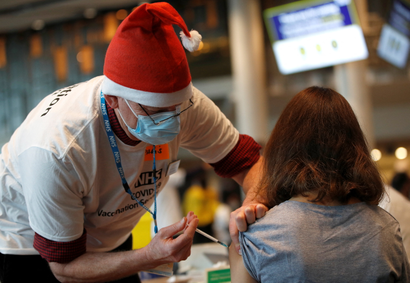 A healthcare professional administers a booster vaccine at a coronavirus disease (COVID-19) pop-up vaccination centre at Wembley Stadium in London, Britain, December 19, 2021.