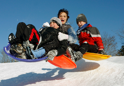 Children sled down a hill