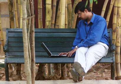 An employee of Infosys Technologies Ltd works on a laptop during his lunch break in Bangalore April ..