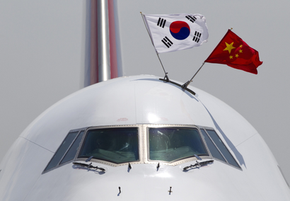 With national flags of South Korea, left, and China, a Boeing 747 plane carrying South Korean President Park Geun-hye arrives at the Beijing Capital International Airport in Beijing Thursday, June 27, 2013. Park arrived for a four-day visit to China to start what would be her first formal discussions with Chinese President Xi Jinping. (AP Photo/Andy Wong)