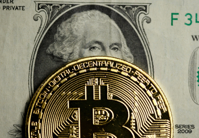 An illustration of a conceptual bitcoin over a dollar bill