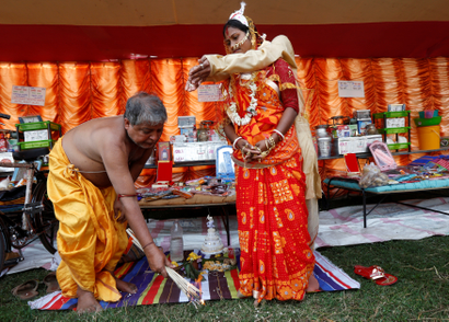 A Hindu priest performs a ritual as a couple take their wedding vows.