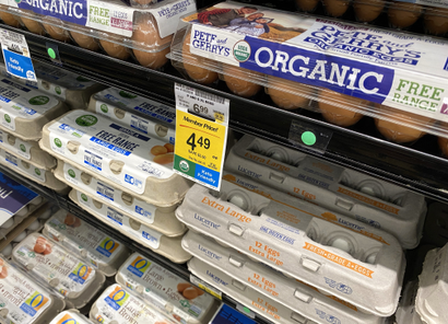 Egg cartons are displayed on a supermarket shelf.